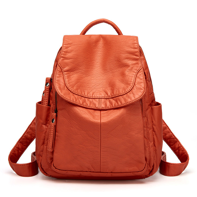 Sac à dos en cuir orange vif, design moderne avec poches latérales et fermeture éclair, idéal pour la mode et le voyage. Accessoire tendance.