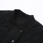 Veste noire matelassée avec col côtelé et boutons-pression, style moderne et élégant, idéale pour l'automne et l'hiver.