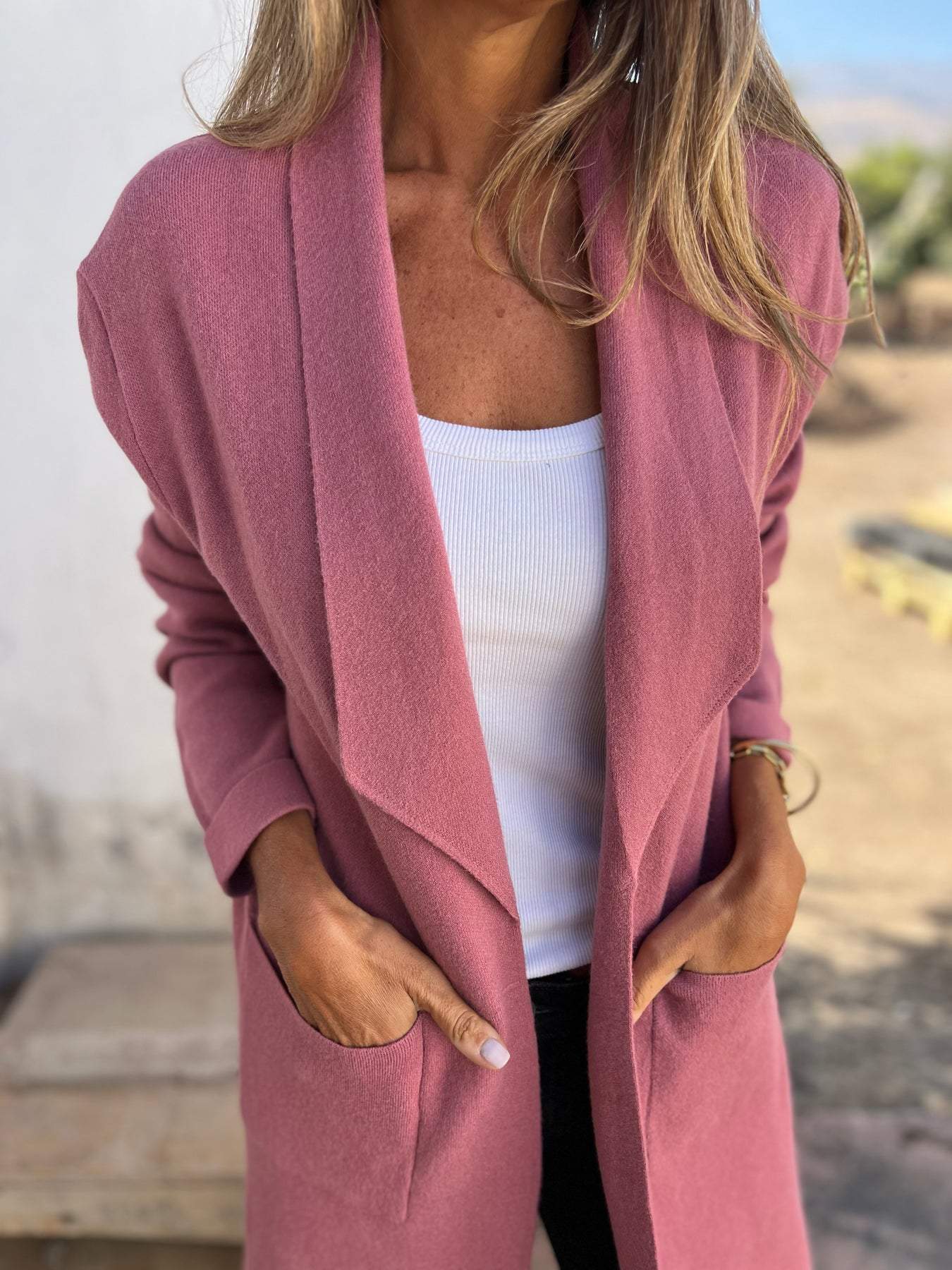 Femme portant un cardigan rose élégant sur un débardeur blanc, style décontracté chic, mode automne, vêtements confortables pour femmes.