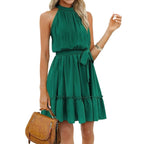 Robe verte sans manches, col haut, ceinture nouée, tenue d'été élégante. Femme tenant un sac à main marron. Mode féminine chic.
