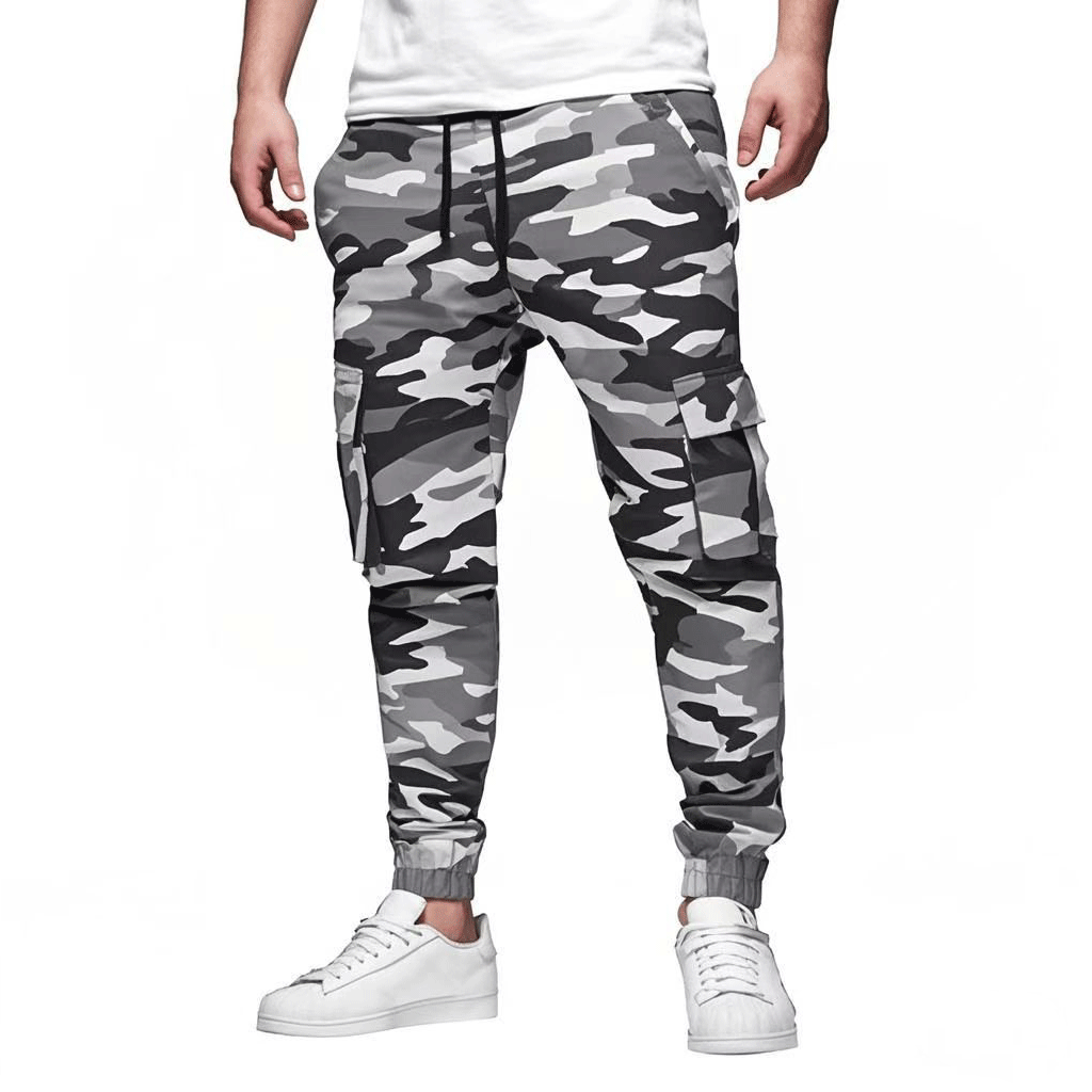 Pantalon cargo camouflage gris pour homme, style militaire, poches latérales, mode urbaine, tendance streetwear, chaussures blanches.