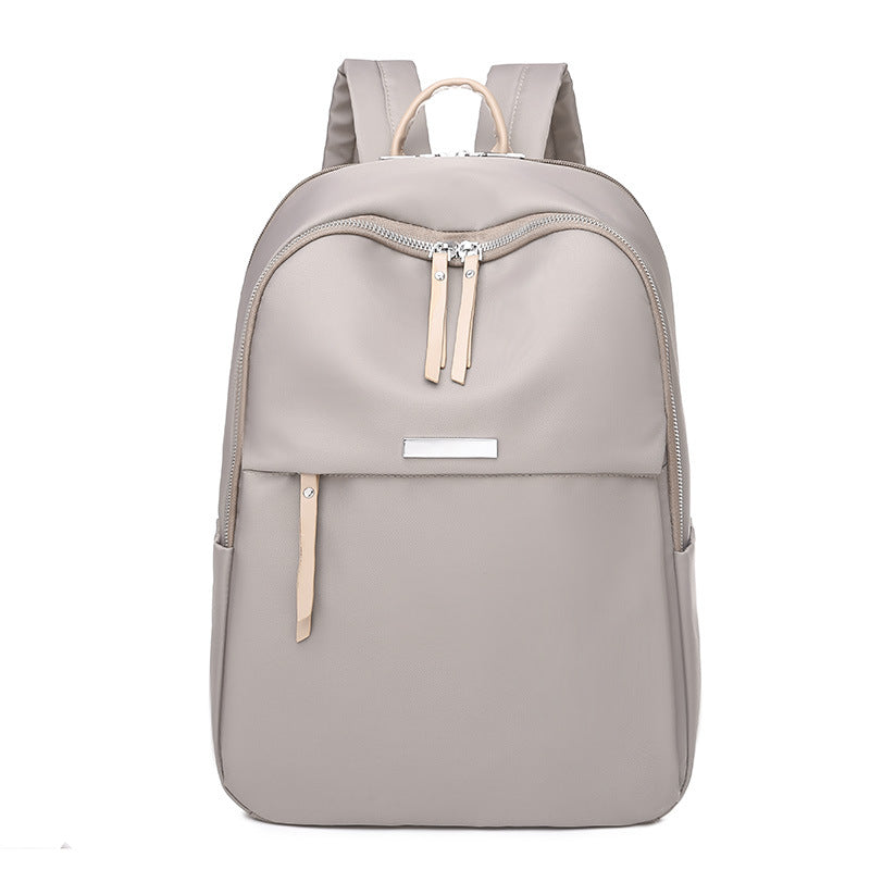 Sac à dos gris clair élégant avec fermeture éclair, design moderne et minimaliste, idéal pour le quotidien, école ou travail. Accessoire tendance.