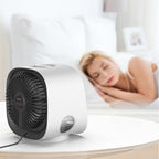Ventilateur de table blanc moderne sur une table, avec une femme endormie en arrière-plan. Design compact, idéal pour chambre à coucher.