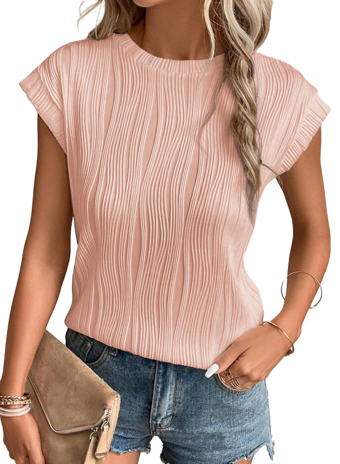 Femme portant un haut rose plissé à manches courtes, associé à un short en jean. Style estival décontracté, accessoirisé avec un sac beige.