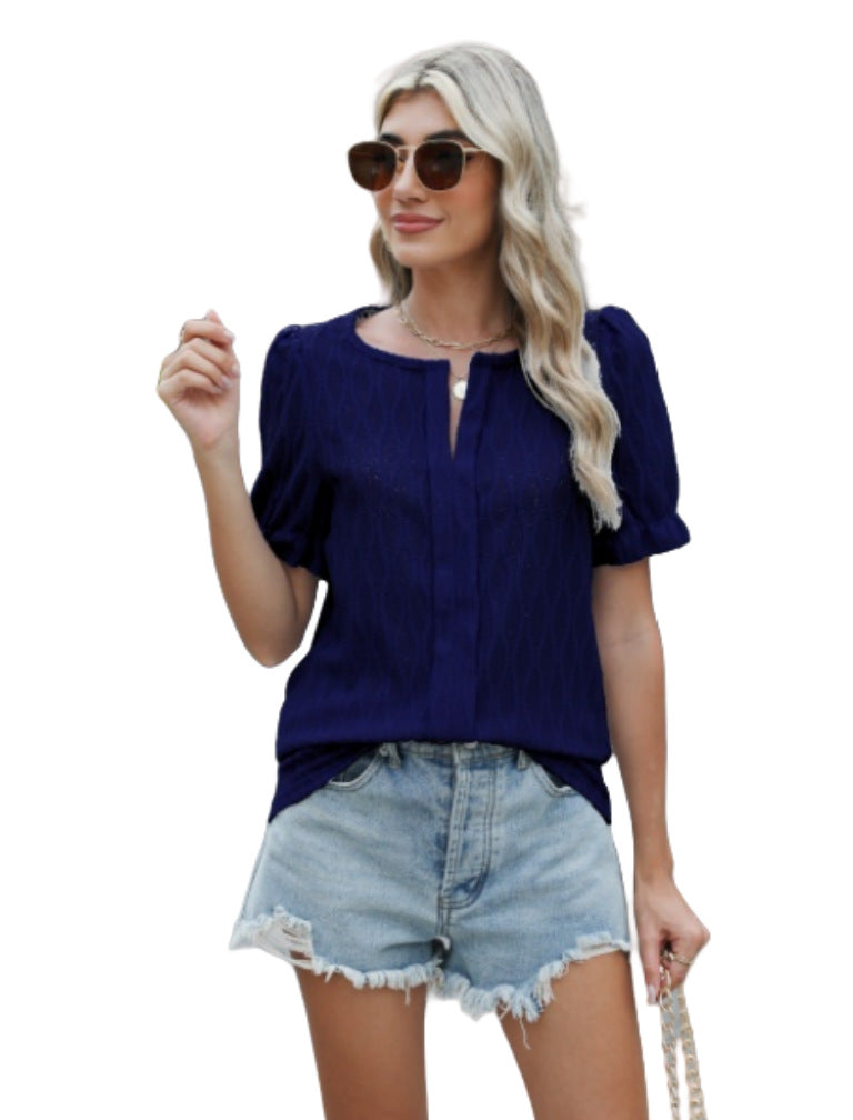 Femme en blouse bleue et short en jean, portant des lunettes de soleil. Mode estivale, tenue décontractée, style moderne.