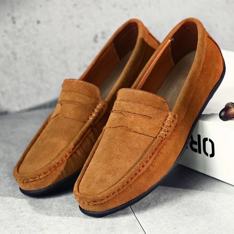 Mocassins en daim marron pour homme, élégants et confortables, posés sur une boîte blanche. Chaussures décontractées idéales pour un style chic.