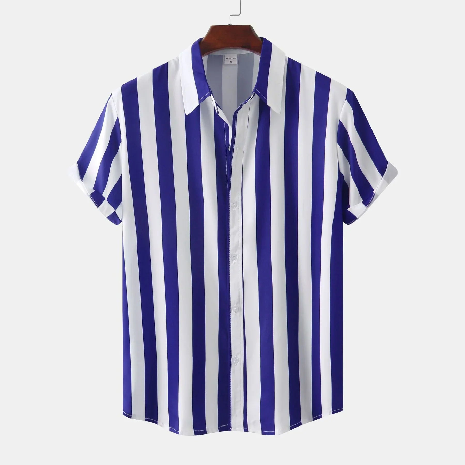 Chemise à manches courtes rayée bleu et blanc, col classique, suspendue sur cintre. Mode homme, style décontracté, tendance été.