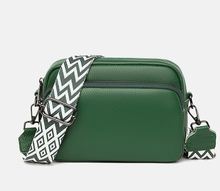 Sac à bandoulière vert en cuir avec sangle à motifs géométriques noir et blanc, design moderne, accessoire mode femme tendance.