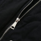 Gros plan sur une fermeture éclair métallique argentée sur une veste noire en tissu épais. Mode, vêtement, détail, textile, style urbain.