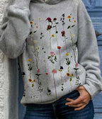 Sweat-shirt gris avec motif floral coloré, fleurs sauvages verticales, style décontracté, mode automne, femme, fond bleu.