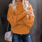 Femme portant un pull en maille orange avec manches bouffantes, sac à main gris, et jeans déchirés. Mode automne, style décontracté chic.
