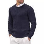 Homme portant un pull bleu marine en maille torsadée, col rond, sur une chemise blanche, style élégant et décontracté, mode masculine automne-hiver.