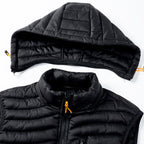 Gilet matelassé noir avec capuche amovible, fermeture éclair orange, design moderne. Vêtement d'extérieur chaud et léger pour l'hiver.
