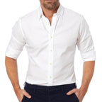 Homme portant une chemise blanche élégante, manches retroussées, avec un pantalon noir. Mode masculine, tenue décontractée chic.