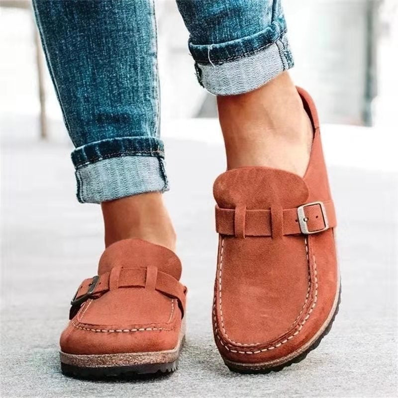 Chaussures mocassins en daim marron pour femme, avec boucle décorative, portées avec un jean retroussé. Mode décontractée, tendance automne.