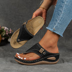 Sandales noires en cuir pour femme, design moderne avec semelle compensée, portées avec un jean. Chaussures d'été élégantes et confortables.
