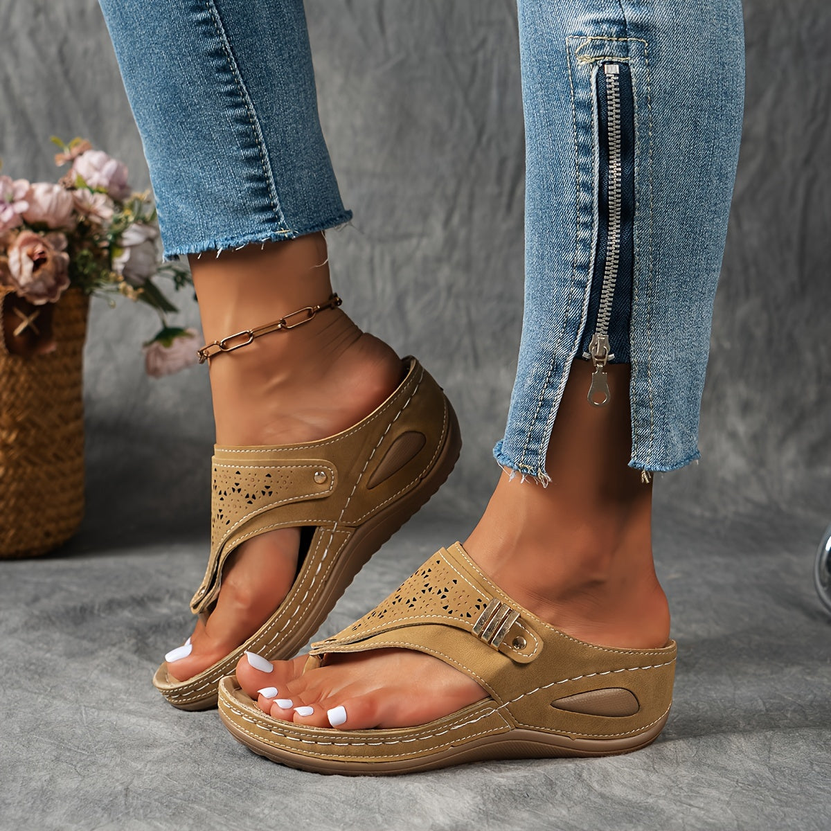 Sandales beiges en cuir avec talon compensé, portées avec un jean bleu zippé. Mode féminine, chaussures d'été confortables et élégantes.