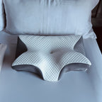 Oreiller ergonomique en mousse à mémoire de forme sur un lit, design orthopédique pour soutien cervical, améliore le confort et la qualité du sommeil.