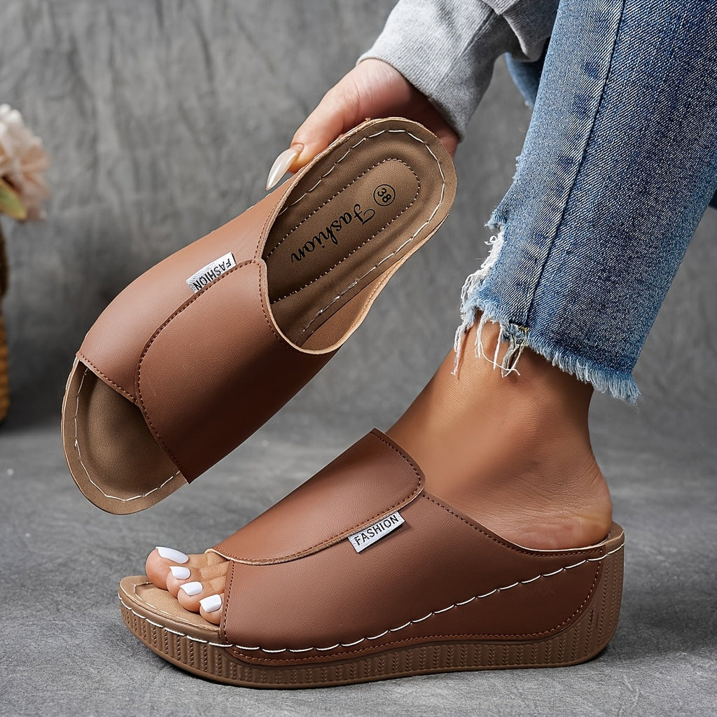 Sandales compensées marron en cuir synthétique, portées avec un jean décontracté. Chaussures mode femme, confortables et tendance.
