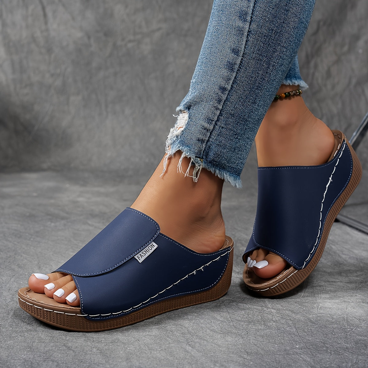 Jeans déchirés et sandales compensées bleues en cuir, style décontracté. Chaussures d'été tendance pour femmes, confortables et modernes.