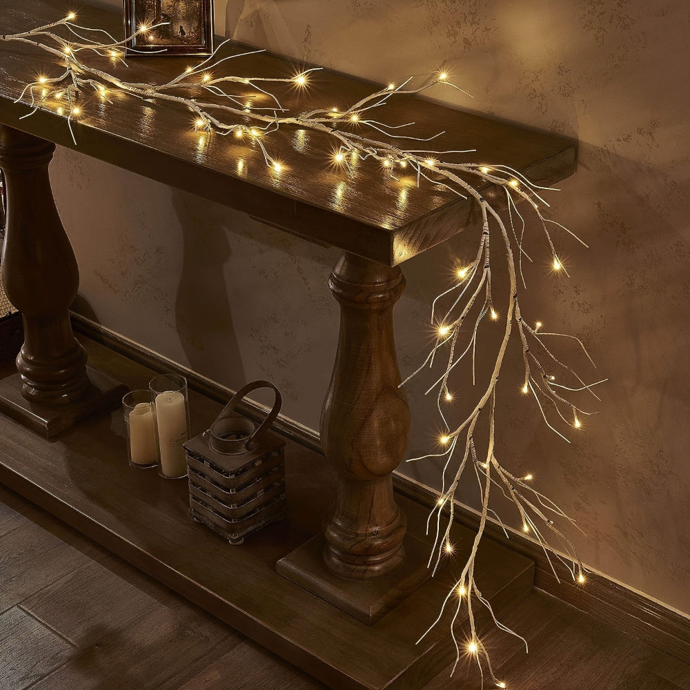 Guirlande lumineuse LED sur une table en bois sombre, décorée de bougies et d'un panier en osier, créant une ambiance chaleureuse et festive.