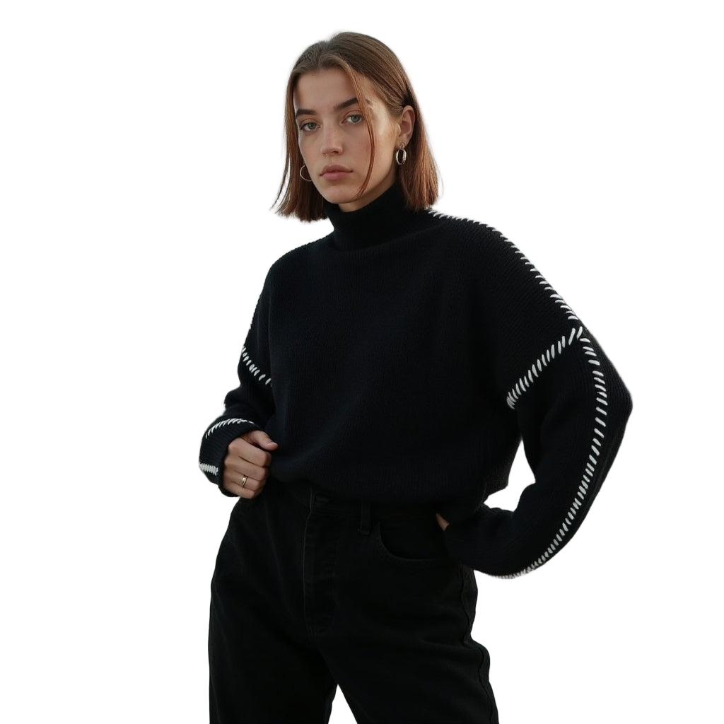 Jeune femme portant un pull noir à col roulé avec détails blancs, posant sur fond blanc. Mode automne-hiver, style décontracté et élégant.