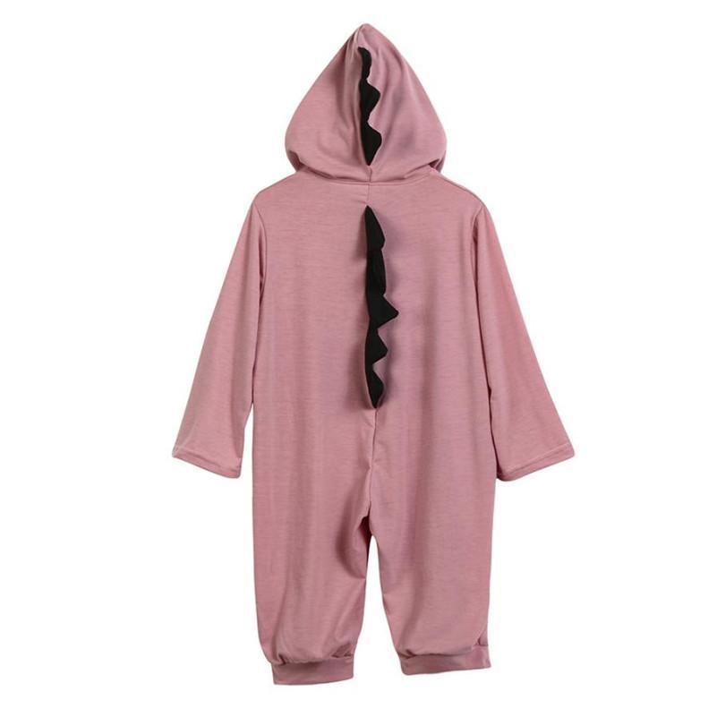 Combinaison bébé dinosaure rose avec capuche, motif écailles noires, manches longues, idéale pour déguisement enfant, vêtement confortable et mignon.