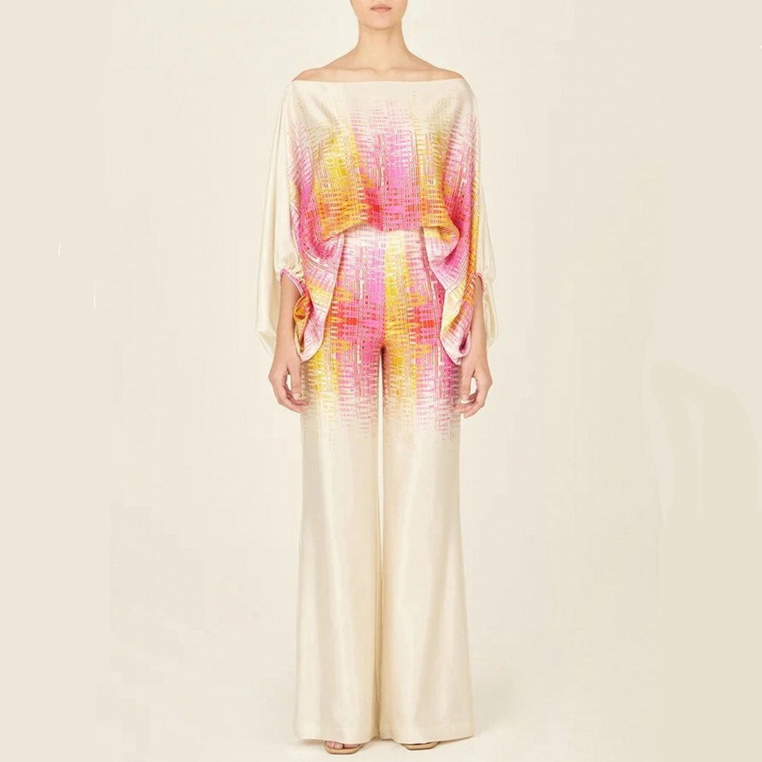 Robe longue élégante en soie beige avec motifs colorés rose et jaune, manches chauve-souris, style chic et moderne, mode féminine tendance.