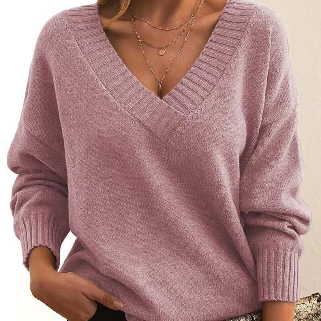 Femme portant un pull rose à col en V, manches longues, avec col côtelé. Mode automne, style décontracté, tendance féminine élégante.