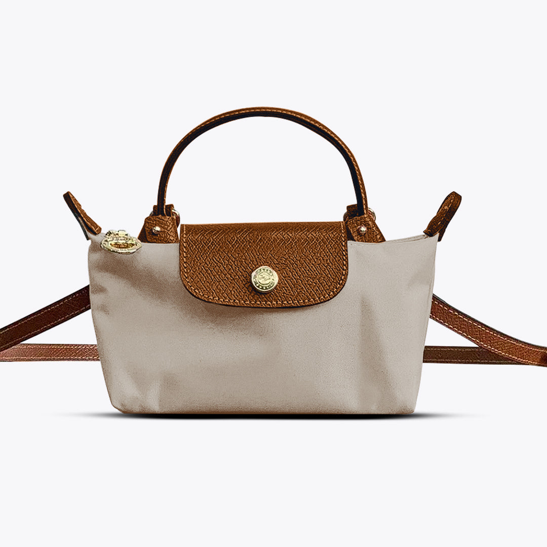 Sac à main beige et marron en toile et cuir, avec bandoulière ajustable et fermeture à rabat. Élégant et pratique pour un usage quotidien.