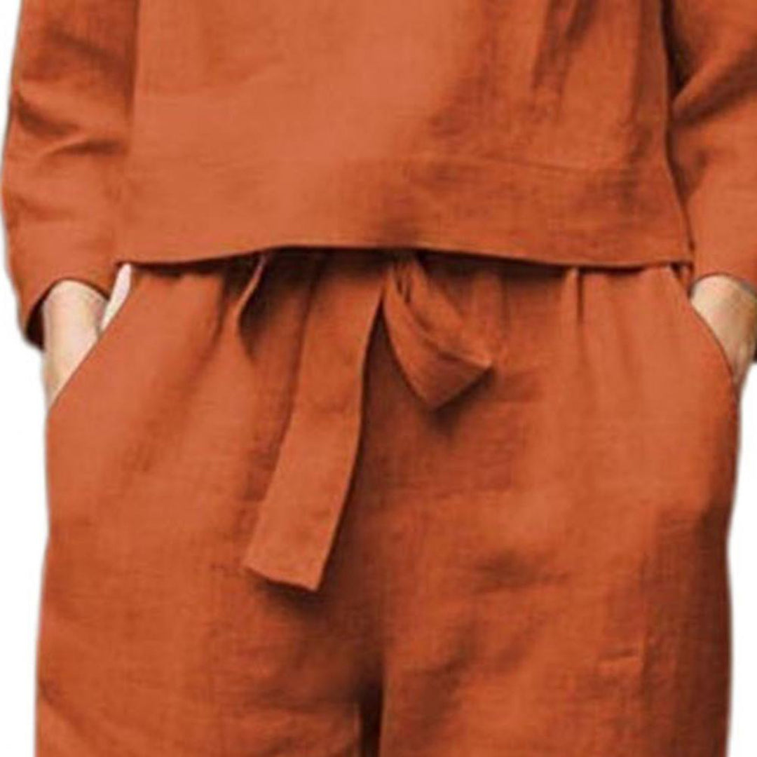 Tenue en lin marron pour femme avec ceinture nouée, manches longues et poches. Mode décontractée, élégance naturelle, style automnal.