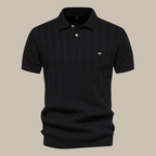 Polo noir élégant en maille fine, manches courtes, col boutonné, logo discret, idéal pour un look chic et décontracté. Mode homme tendance.