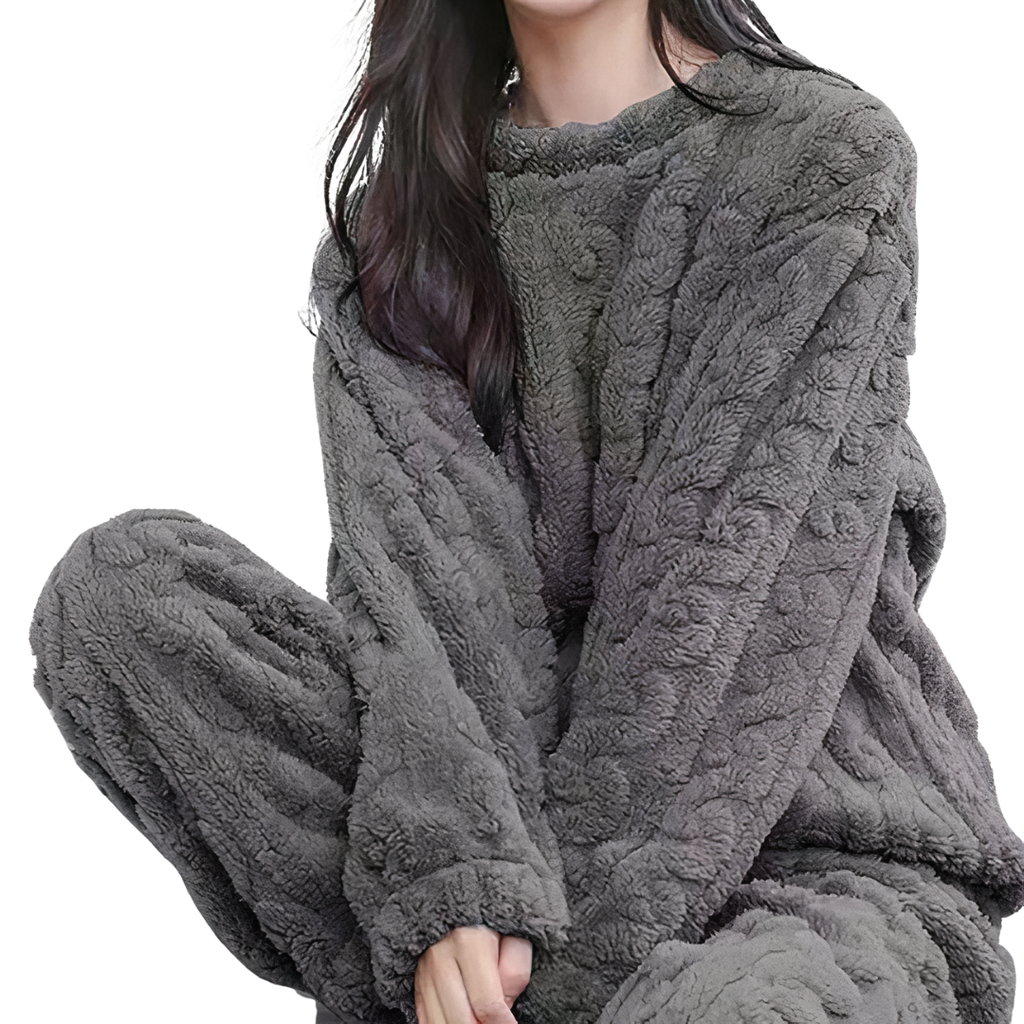 Femme portant un ensemble pyjama en polaire gris, confortable et chaud, idéal pour l'hiver. Mode détente, vêtements d'intérieur douillets.