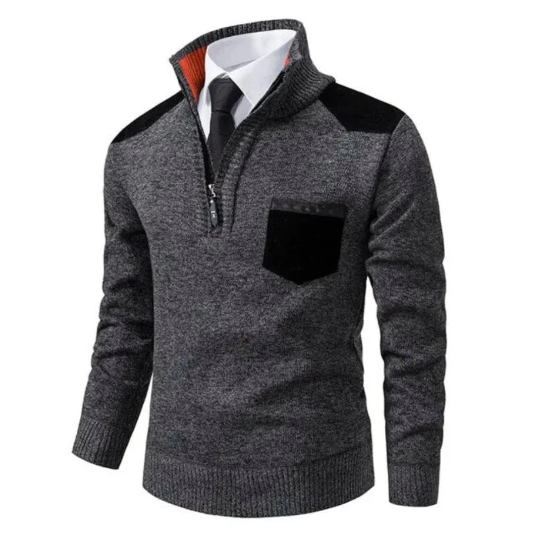 Pull-over gris à col zippé, poche poitrine noire, porté sur chemise blanche et cravate noire. Mode homme élégante, tenue automne-hiver.