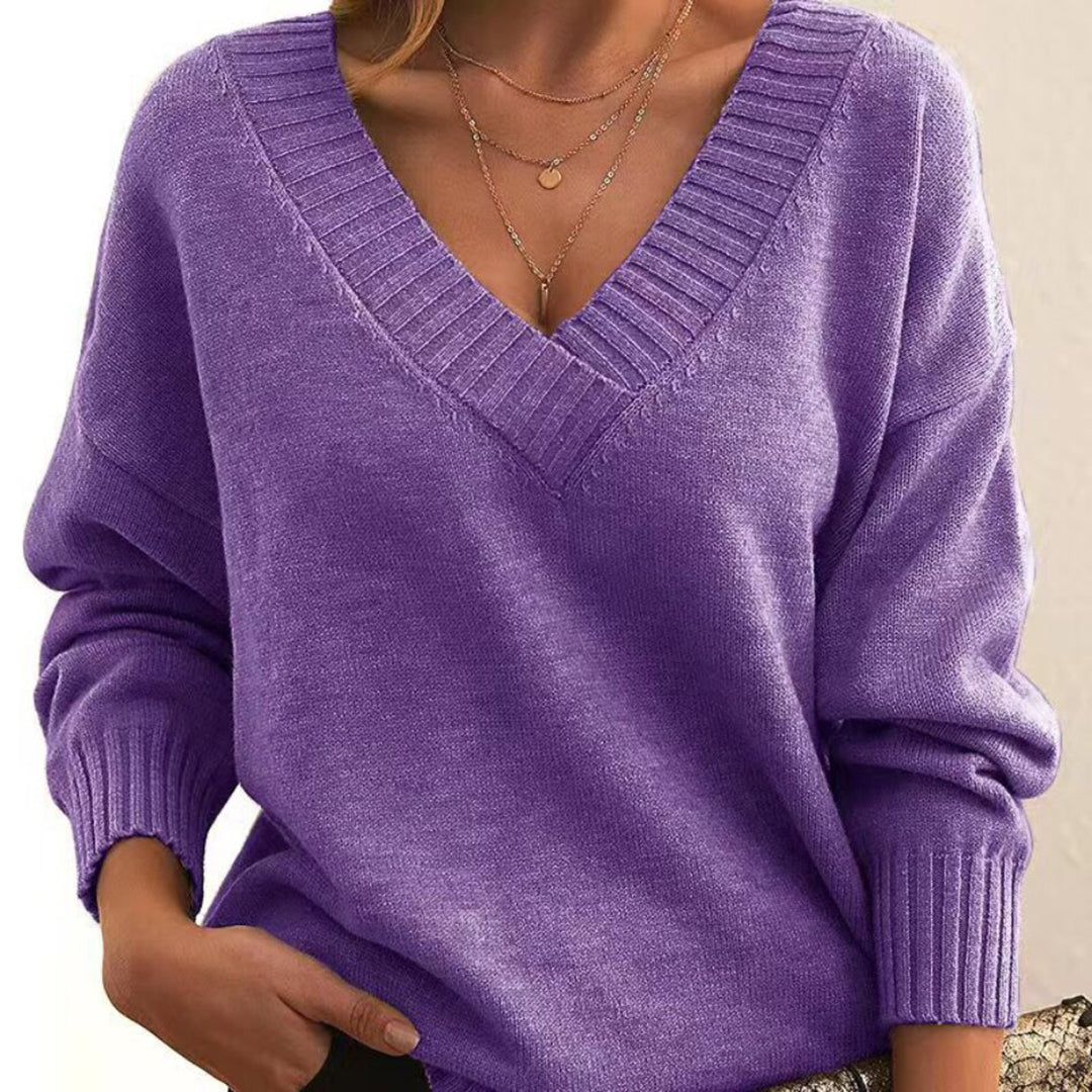 Femme portant un pull violet à col en V, manches longues, avec col côtelé. Mode automne, style décontracté, tendance féminine élégante.