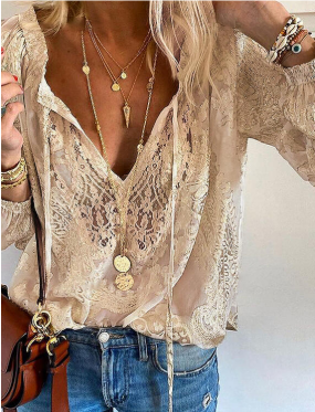 Blouse en dentelle beige élégante portée avec des colliers dorés superposés et un jean décontracté, style bohème chic, mode féminine tendance.