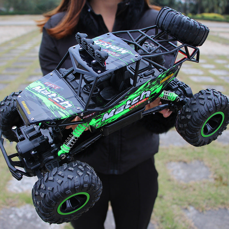 Voiture télécommandée tout-terrain verte et noire, design robuste, pneus larges, tenue par une personne en extérieur. Modèle de buggy RC performant.