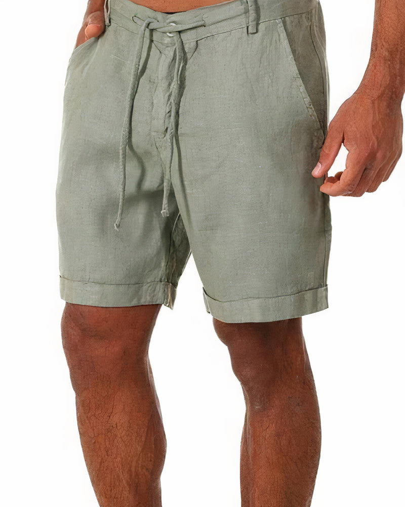 Short en lin vert pour homme avec cordon de serrage, poches latérales et ourlets retroussés. Mode estivale, confort, style décontracté.
