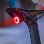Selle de vélo avec feu arrière LED rouge allumé, sécurité cycliste, accessoire vélo nocturne, éclairage vélo urbain, visibilité accrue.