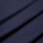 Tissu bleu marine en coton, texture douce et lisse, idéal pour vêtements élégants et confortables. Parfait pour couture et mode tendance.