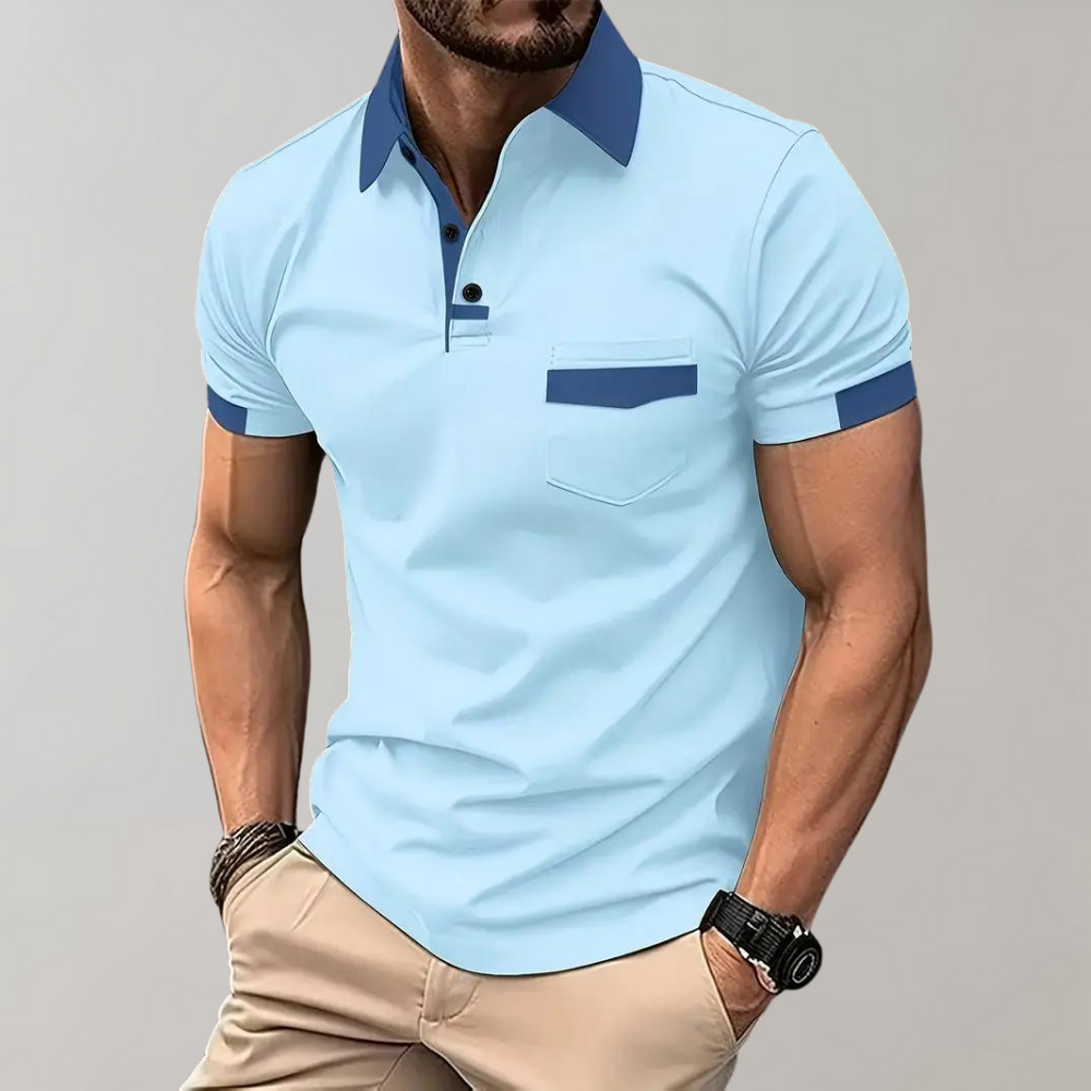 Homme portant un polo bleu clair avec col contrasté bleu foncé, poche poitrine, manches courtes, associé à un pantalon beige. Mode masculine élégante.