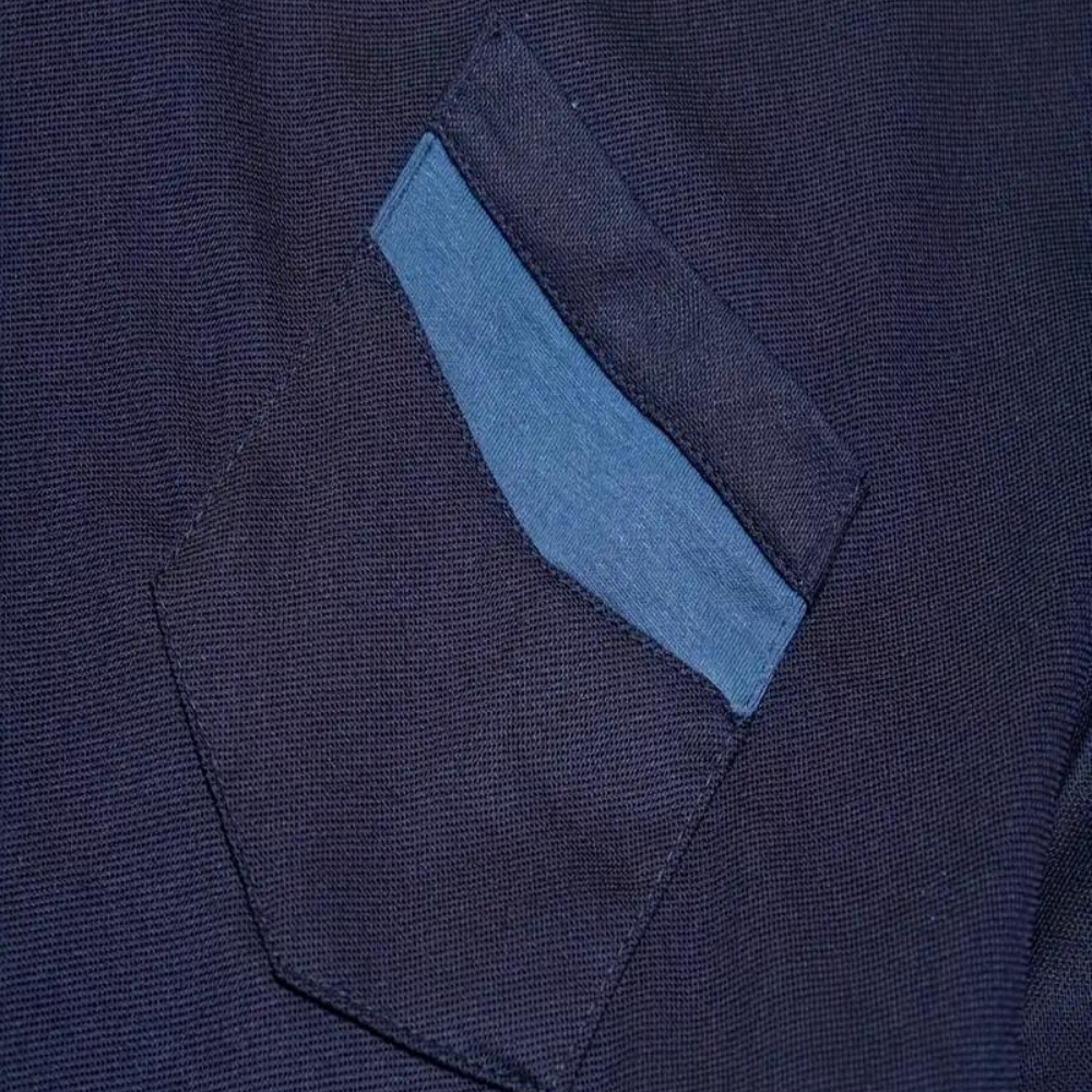 Poche de chemise en tissu bleu marine avec rabat bleu clair, mode homme élégante, détail textile, style décontracté chic.