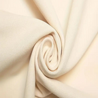 Tissu beige enroulé, texture douce et lisse, idéal pour couture et décoration intérieure. Matériau polyvalent et élégant pour projets créatifs.