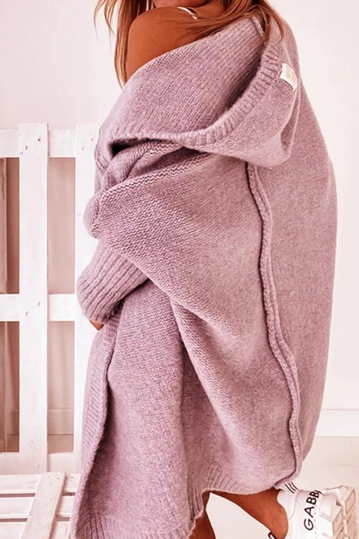 Femme portant un cardigan en laine rose, ample et confortable, avec capuche. Mode automne-hiver, style décontracté, tendance cosy.