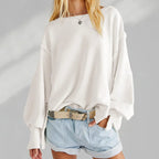 Femme en pull blanc ample et short en jean, style décontracté. Mode féminine, tenue estivale, look tendance.
