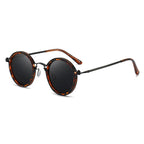 Lunettes de soleil rondes vintage avec monture écaille de tortue et verres noirs, style rétro chic, accessoire mode tendance pour homme et femme.