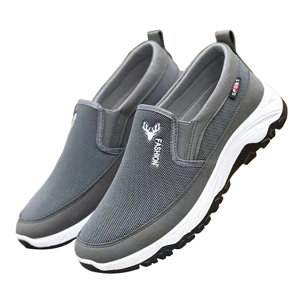 Chaussures de sport grises pour hommes, style slip-on, semelle blanche antidérapante, logo mode, confort et légèreté, idéales pour la marche.