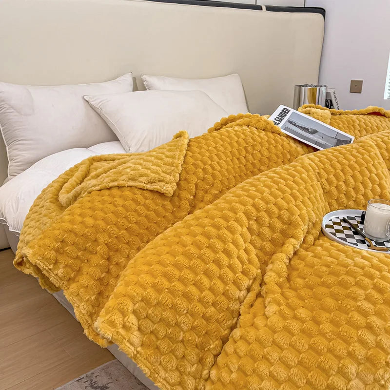Lit avec couverture en peluche jaune texturée, oreillers blancs, plateau avec tasse et magazine. Décor de chambre moderne et confortable.