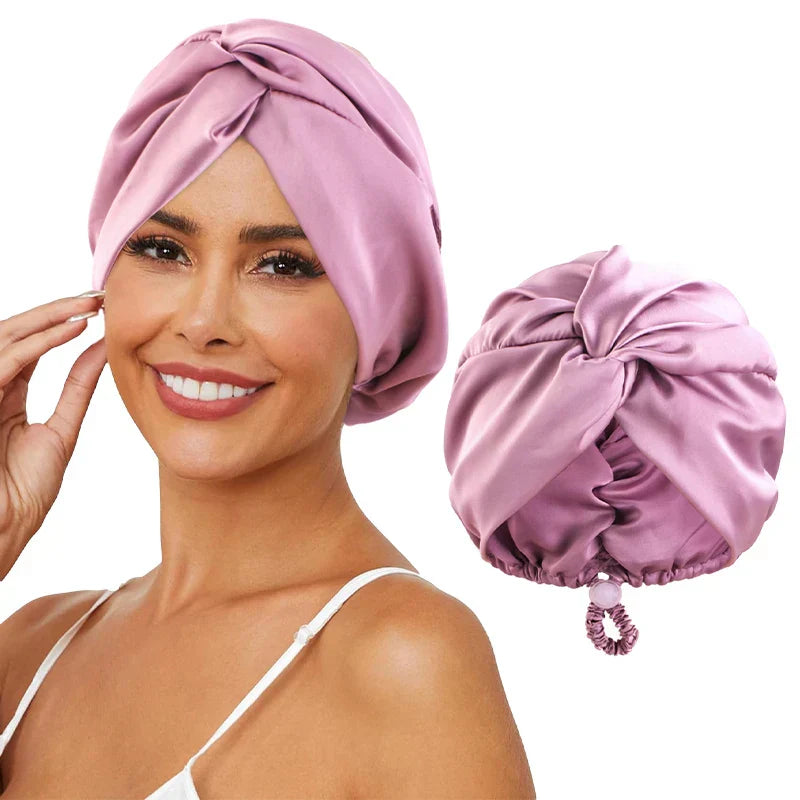 Femme souriante portant un turban en satin rose, accessoire de mode élégant pour cheveux, avec un turban similaire à côté.