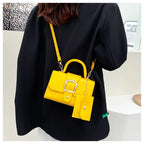 Sac à main jaune vif avec bandoulière et pochette assortie, porté par une personne en manteau noir. Accessoire de mode tendance et coloré.